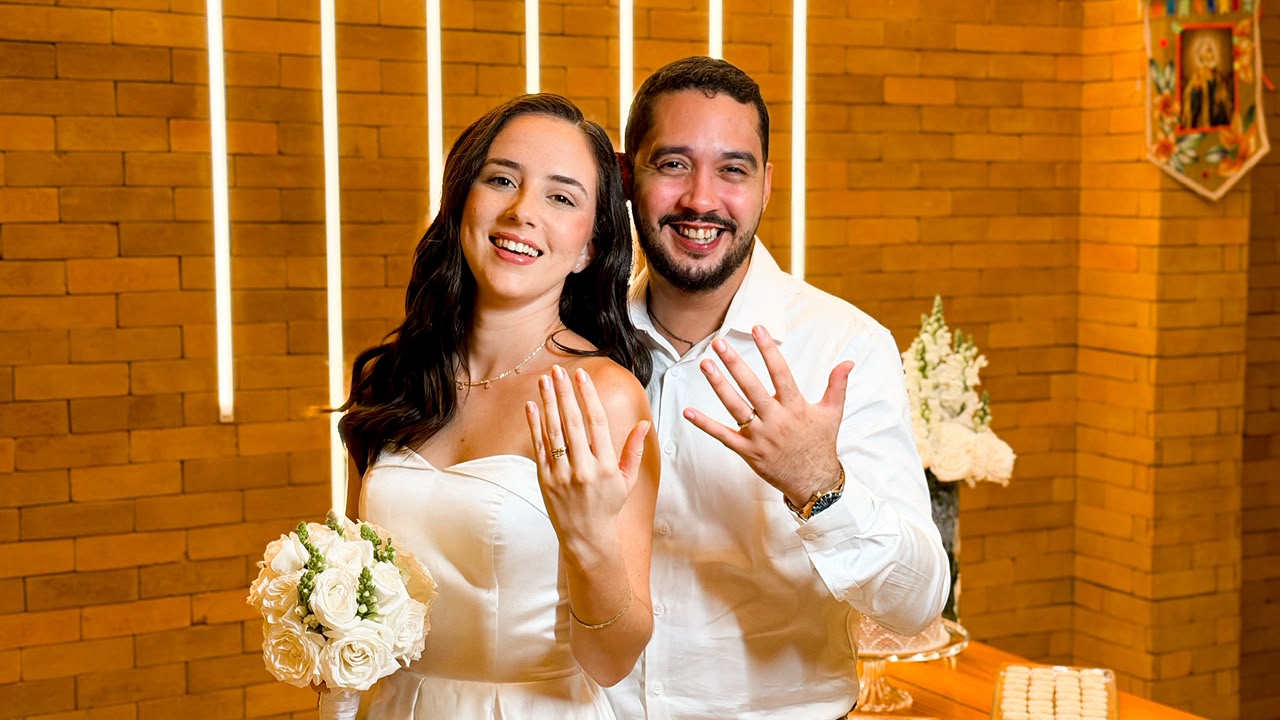 Ana e Paulo exibindo as alianças sorrindo